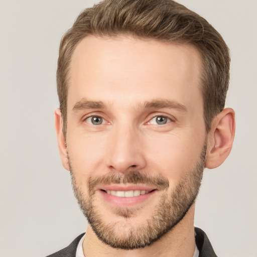 Joyful white young-adult male with short  brown hair and grey eyes