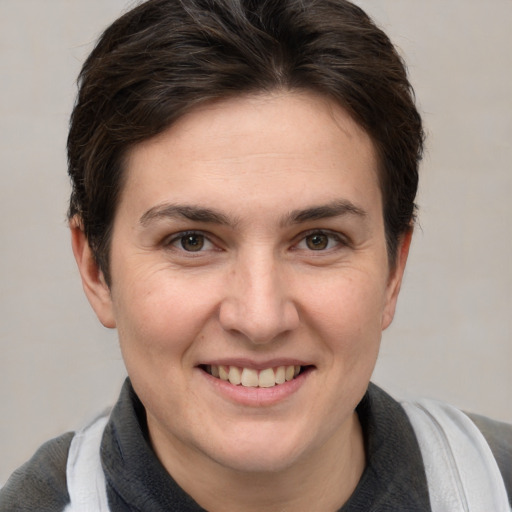 Joyful white young-adult female with short  brown hair and grey eyes