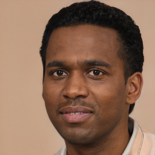 Joyful black young-adult male with short  black hair and brown eyes