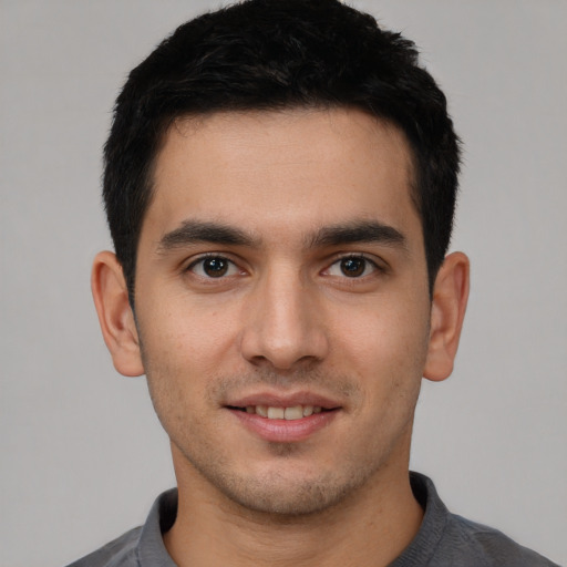 Joyful white young-adult male with short  black hair and brown eyes