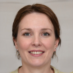 Joyful white adult female with medium  brown hair and blue eyes