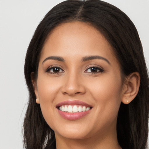 Joyful latino young-adult female with long  brown hair and brown eyes