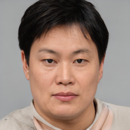 Joyful asian adult male with short  brown hair and brown eyes
