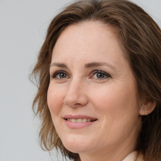 Joyful white adult female with medium  brown hair and grey eyes