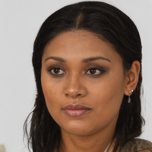 Joyful black young-adult female with long  brown hair and brown eyes