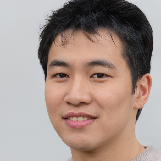 Joyful asian young-adult male with short  black hair and brown eyes