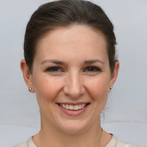 Joyful white young-adult female with medium  brown hair and grey eyes