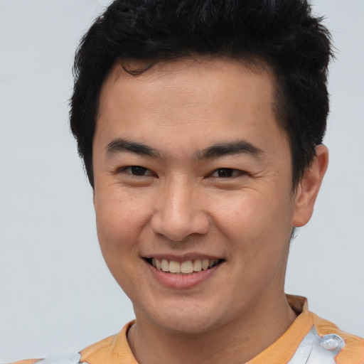 Joyful asian young-adult male with short  brown hair and brown eyes