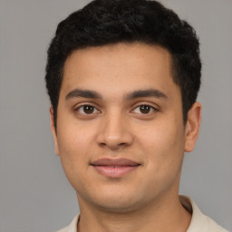 Joyful latino young-adult male with short  brown hair and brown eyes