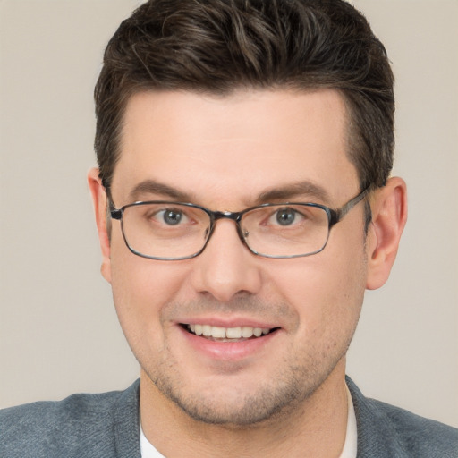 Joyful white young-adult male with short  brown hair and grey eyes