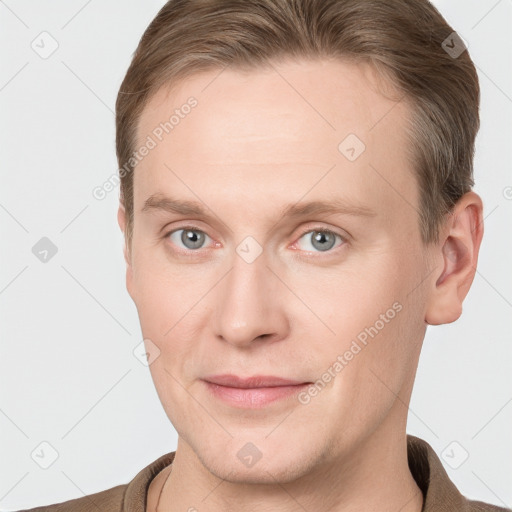 Joyful white young-adult male with short  brown hair and grey eyes