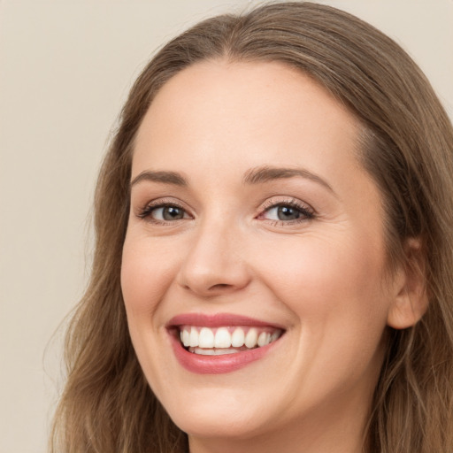 Joyful white young-adult female with long  brown hair and grey eyes