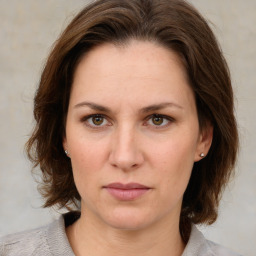 Joyful white young-adult female with medium  brown hair and green eyes