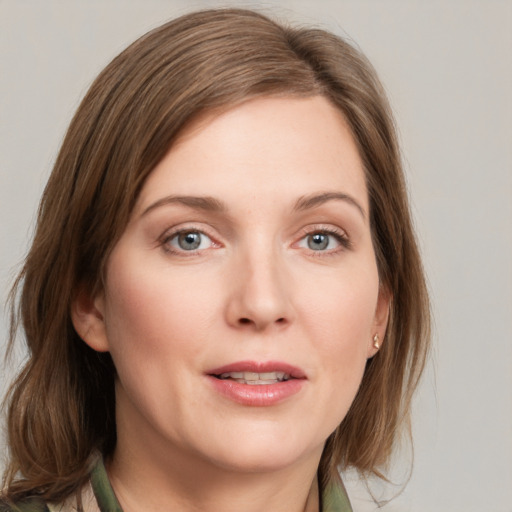 Joyful white young-adult female with medium  brown hair and green eyes