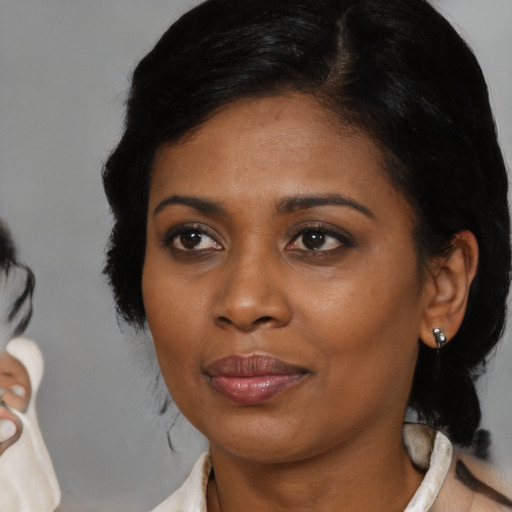 Joyful black young-adult female with medium  brown hair and brown eyes