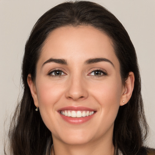 Joyful white young-adult female with long  brown hair and brown eyes