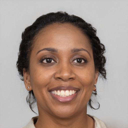 Joyful black young-adult female with long  brown hair and brown eyes