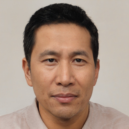 Joyful asian adult male with short  black hair and brown eyes