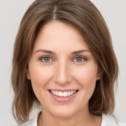 Joyful white young-adult female with medium  brown hair and green eyes