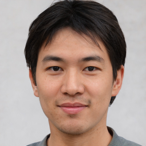 Joyful asian young-adult male with short  black hair and brown eyes
