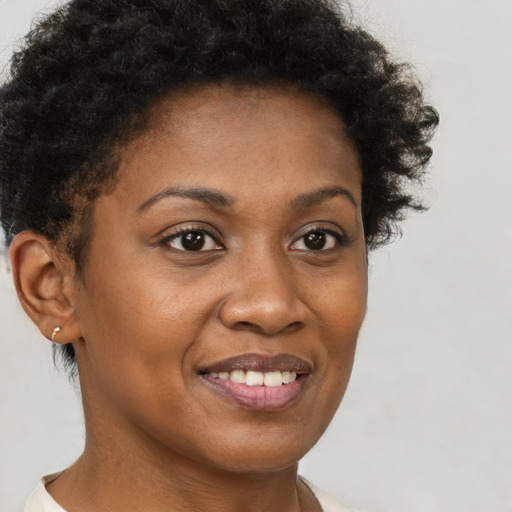Joyful black young-adult female with short  brown hair and brown eyes