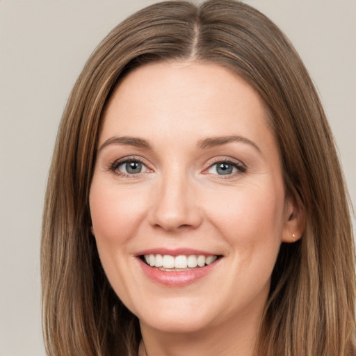 Joyful white young-adult female with long  brown hair and grey eyes