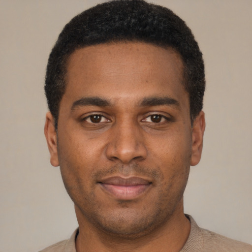 Joyful black young-adult male with short  black hair and brown eyes