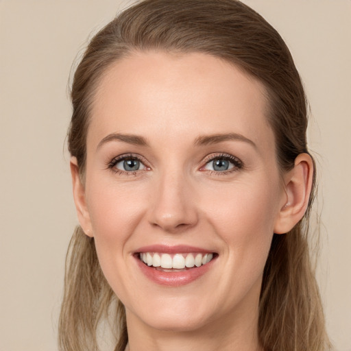 Joyful white young-adult female with long  brown hair and blue eyes