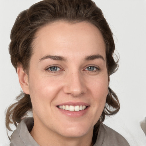 Joyful white young-adult female with medium  brown hair and grey eyes