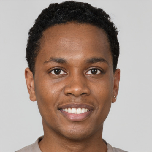 Joyful black young-adult male with short  black hair and brown eyes