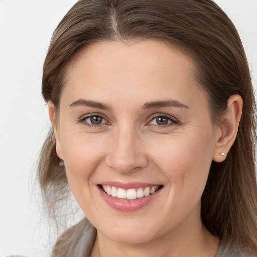 Joyful white young-adult female with long  brown hair and grey eyes