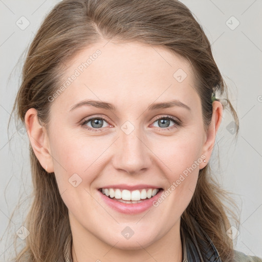 Joyful white young-adult female with long  brown hair and blue eyes