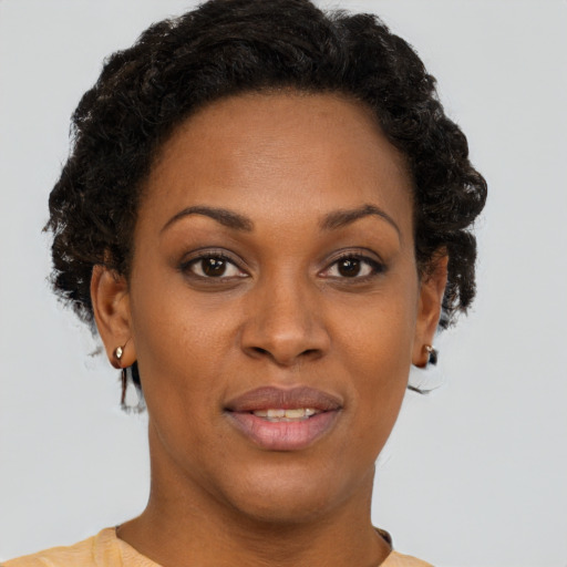 Joyful black young-adult female with short  brown hair and brown eyes