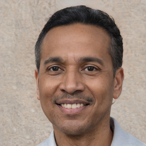 Joyful latino adult male with short  black hair and brown eyes