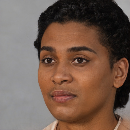 Joyful black young-adult female with short  black hair and brown eyes