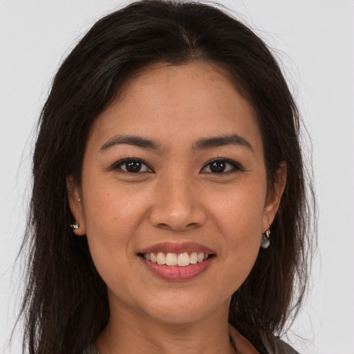 Joyful latino young-adult female with long  brown hair and brown eyes