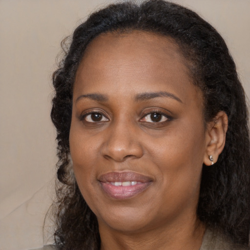 Joyful black adult female with long  brown hair and brown eyes