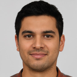 Joyful latino young-adult male with short  brown hair and brown eyes