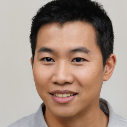 Joyful asian young-adult male with short  black hair and brown eyes