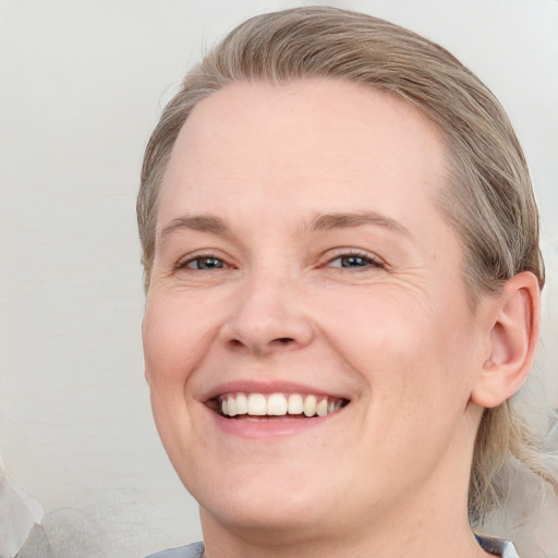 Joyful white young-adult female with medium  brown hair and blue eyes