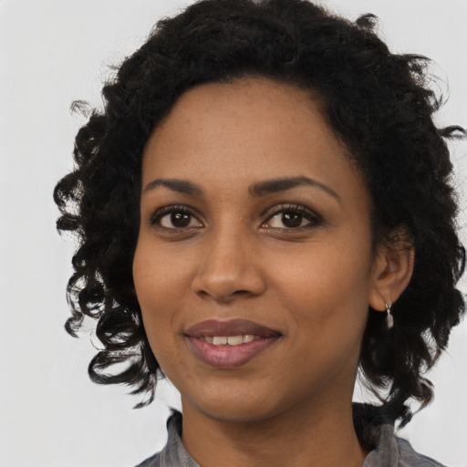 Joyful black young-adult female with medium  black hair and brown eyes
