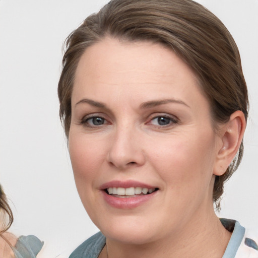 Joyful white young-adult female with medium  brown hair and blue eyes