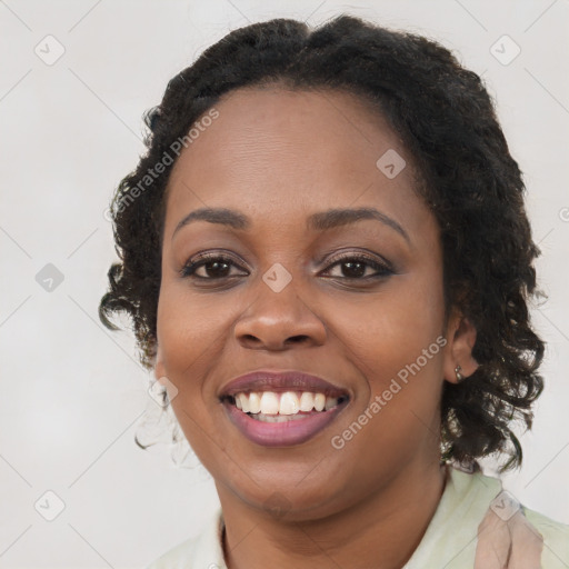 Joyful black young-adult female with long  brown hair and brown eyes