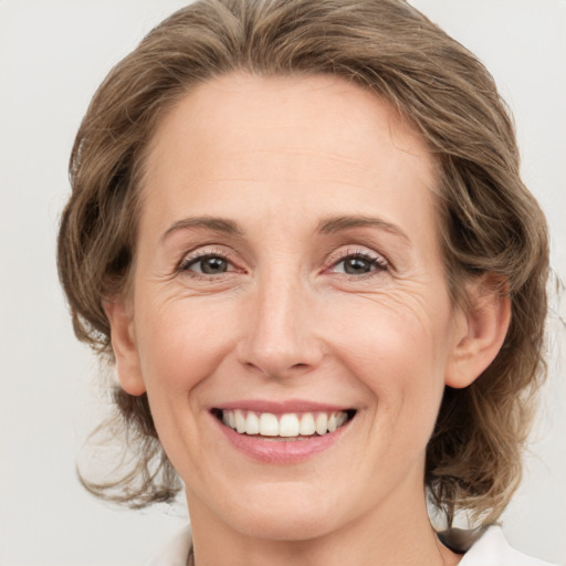 Joyful white adult female with medium  brown hair and grey eyes