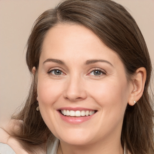 Joyful white young-adult female with long  brown hair and grey eyes