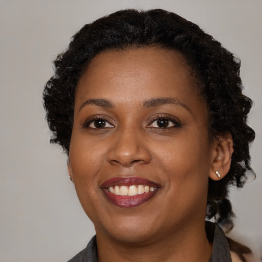 Joyful black adult female with medium  black hair and brown eyes