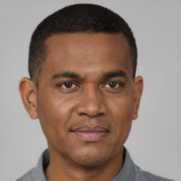 Joyful black young-adult male with short  black hair and brown eyes