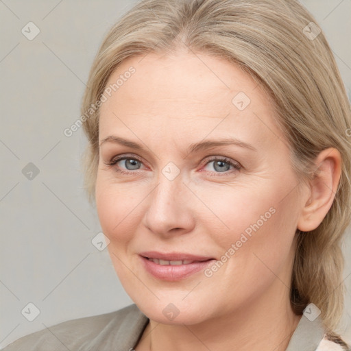 Joyful white adult female with medium  brown hair and blue eyes