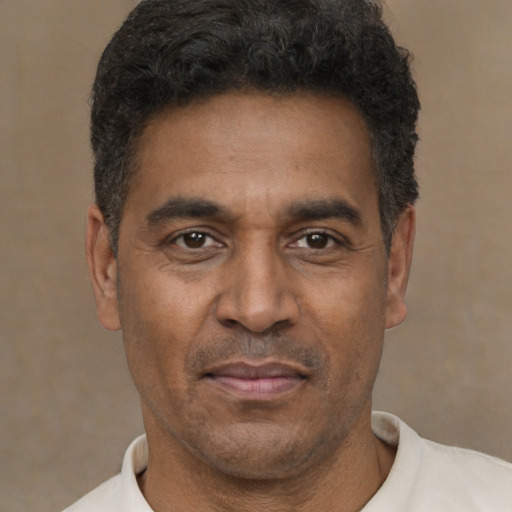 Joyful latino adult male with short  black hair and brown eyes