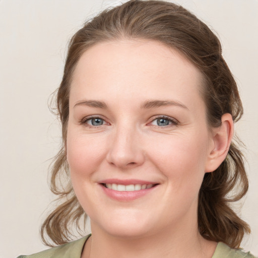 Joyful white young-adult female with medium  brown hair and green eyes